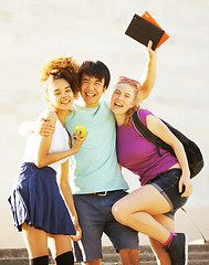 Image showing cute group of teenages at the building of university with books huggings