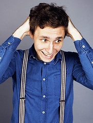Image showing young goofy man with pimples pointing in studio
