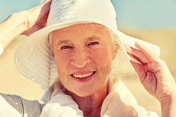 Image showing happy senior woman in sun hat on summer beach