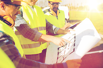 Image showing close up of builders with blueprint at building