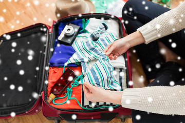 Image showing close up of woman packing travel bag for vacation