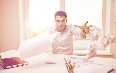 Image showing angry businessman throwing papers in office