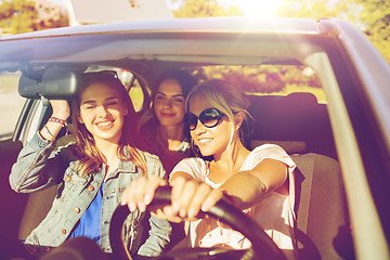 Image showing happy teenage girls or young women driving in car