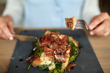 Image showing woman eating prosciutto ham salad at restaurant