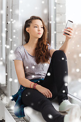 Image showing sad pretty teenage girl with smartphone texting