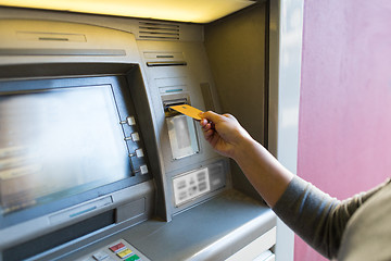 Image showing close up of woman inserting card to atm machine