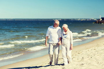 Image showing happy senior couple holding hands on summer beach