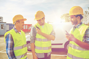 Image showing happy male builders in vests with walkie talkie