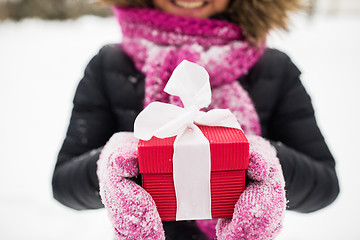 Image showing close up of woman with christmas gift outdoors