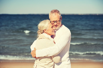 Image showing happy senior couple hugging on summer beach