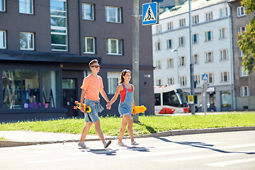 Image showing teenage couple with skateboards on city street