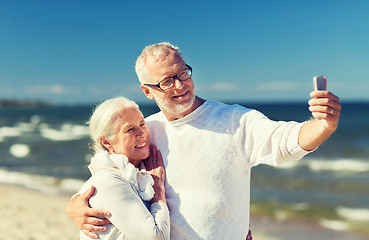 Image showing happy senior couple hugging on summer beach