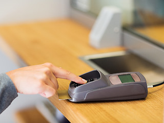 Image showing hand entering pin code to card reader terminal