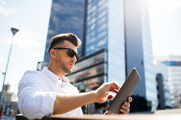 Image showing man with tablet pc sitting on city street bench