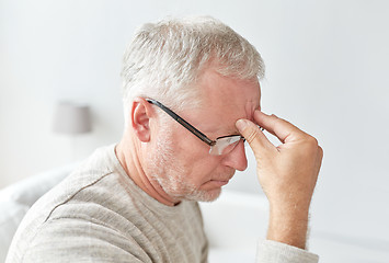 Image showing senior man suffering from headache at home