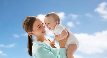 Image showing happy young mother with little baby over blue sky