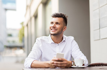 Image showing man with smartphone and coffee at city cafe