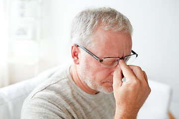 Image showing senior man suffering from headache at home