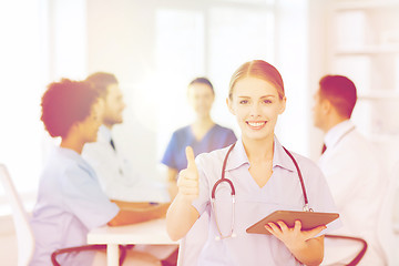 Image showing happy doctor with tablet pc over team at clinic