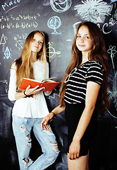 Image showing back to school after summer vacations, two teen real girls in classroom with blackboard painted together