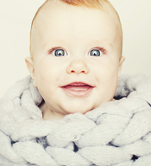 Image showing little cute red head baby in scarf all over him close up isolate