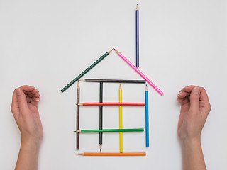 Image showing Female hand made of pencils on paper funny house