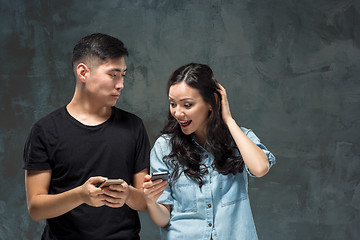 Image showing Asian young couple using cellphone, closeup portrait.