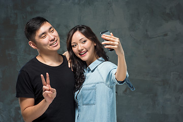 Image showing Portrait of smiling Korean couple on a gray