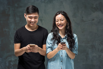 Image showing Asian young couple using cellphone, closeup portrait.