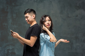 Image showing Asian young couple using cellphone, closeup portrait.