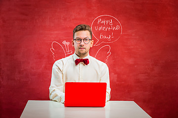 Image showing Young funny man with laptop at St. Valentine\'s Day