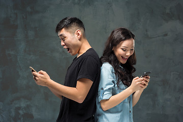 Image showing Asian young couple using cellphone, closeup portrait.