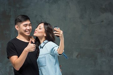 Image showing Portrait of smiling Korean couple on a gray