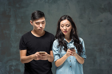 Image showing Asian young couple using cellphone, closeup portrait.