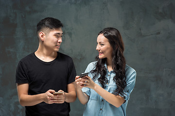 Image showing Asian young couple using cellphone, closeup portrait.