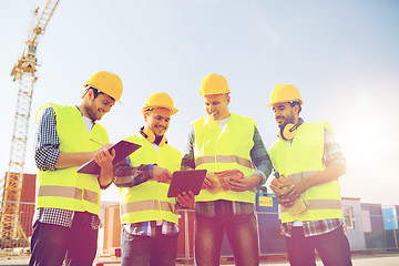 Image showing group of smiling builders with tablet pc outdoors