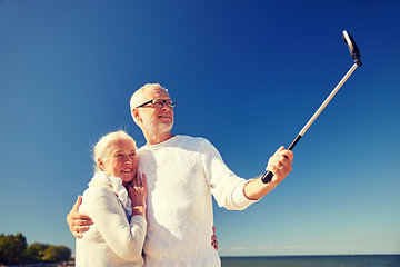 Image showing seniors with smartphone taking selfie on beach