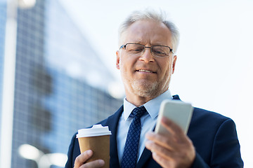 Image showing businessman with smartphone and coffee in city