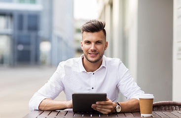 Image showing man with tablet pc and coffee at city cafe