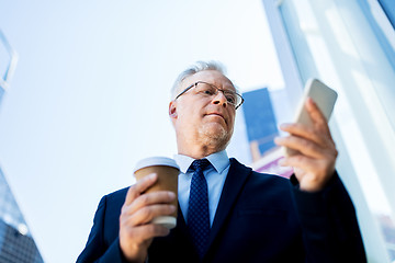 Image showing businessman with smartphone and coffee in city