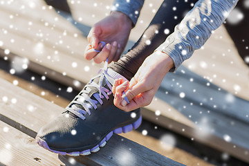 Image showing close up of sporty woman tying shoelaces outdoors