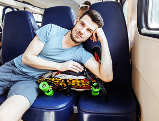 Image showing young pretty modern hipster guy traveller on train with skateboa