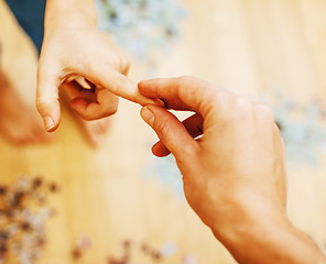 Image showing little kid playing with puzzles on wooden floor together with pa