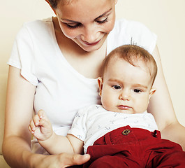 Image showing young brunette happy mother holding toddler baby son, breast-fee