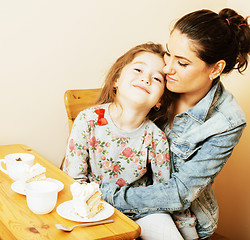 Image showing young mother with daughter on kitchen drinking tea together hugg