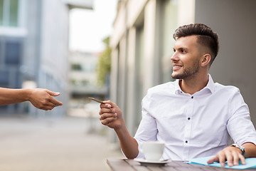 Image showing man with credit card paying for coffee at cafe