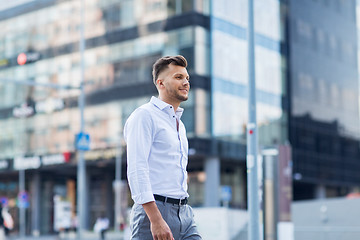 Image showing young man walking along city street