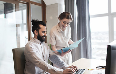 Image showing happy creative team with computer in office