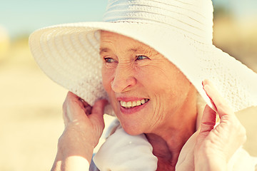 Image showing happy senior woman in sun hat on summer beach