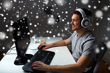 Image showing man in headset playing computer video game at home